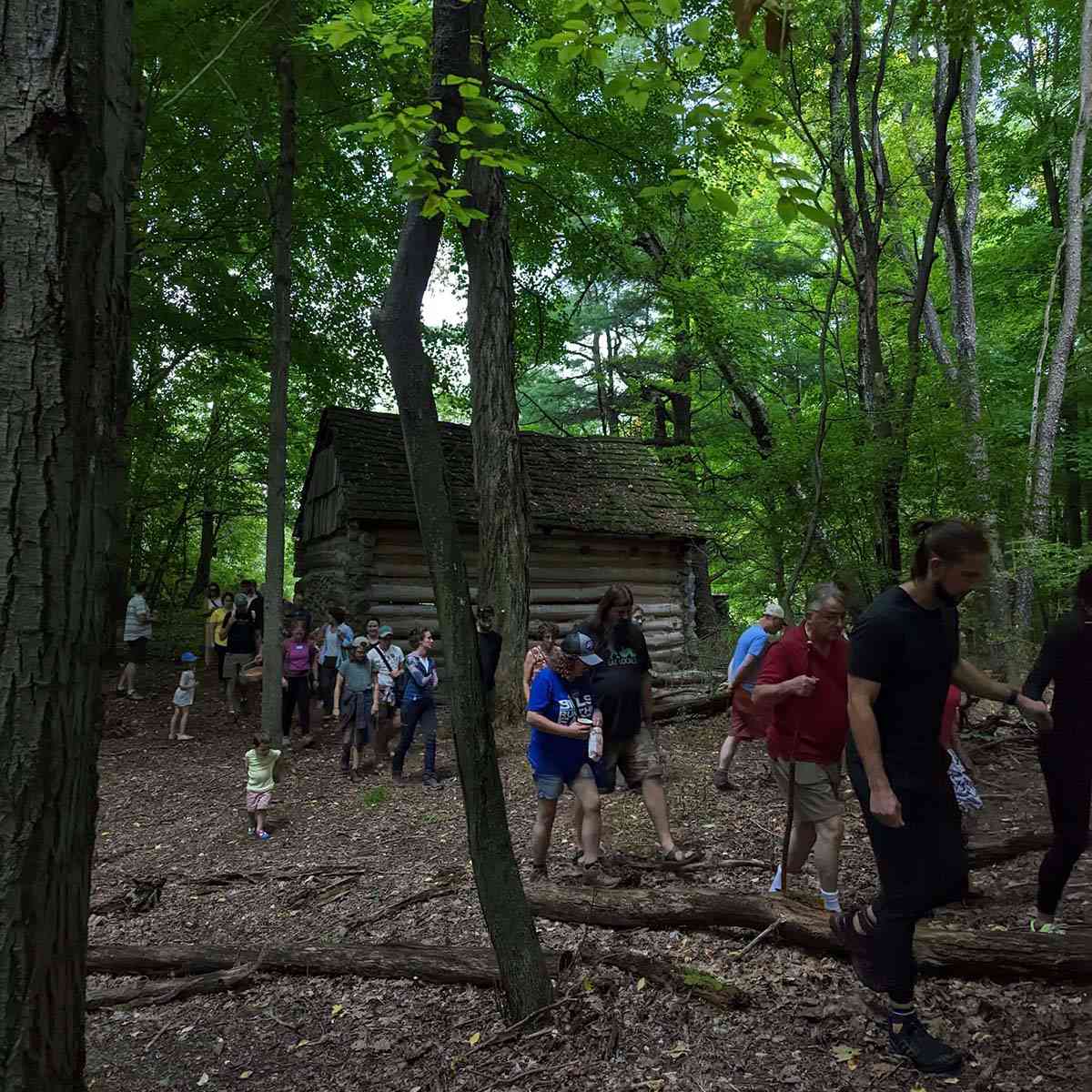 group walking past the pioneer cabin
